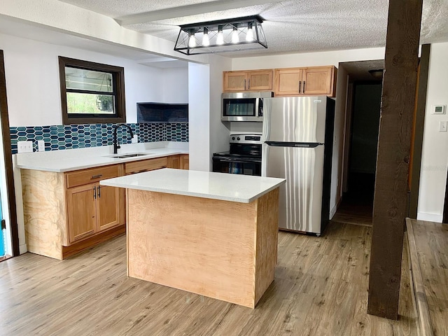 kitchen featuring sink, stainless steel appliances, a textured ceiling, and light wood-type flooring