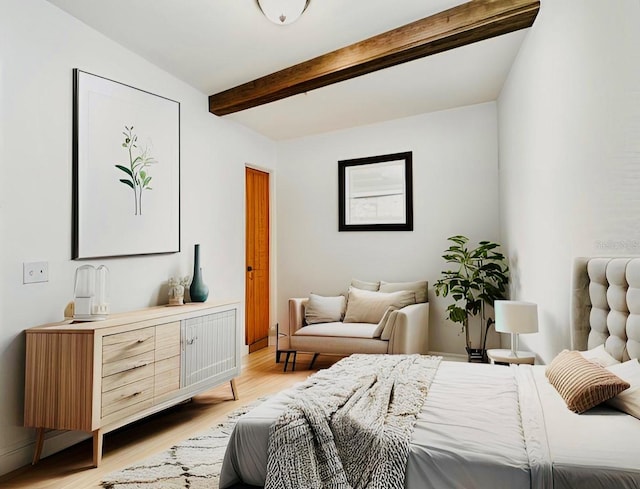 bedroom with light wood-style floors and beamed ceiling