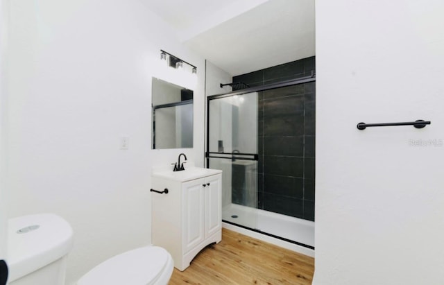 full bath with toilet, a shower stall, and wood finished floors