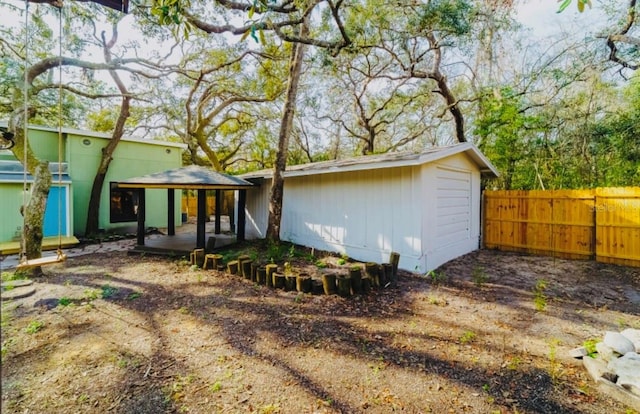 rear view of property featuring fence and a gazebo