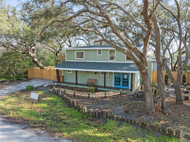 view of front of home with roof with shingles and fence