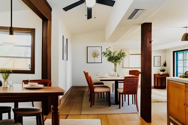 dining area with lofted ceiling, ceiling fan, light wood finished floors, and visible vents