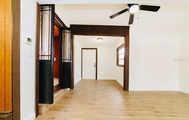 hall featuring light wood-type flooring and baseboards