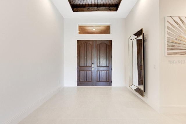 entryway with a tray ceiling and baseboards