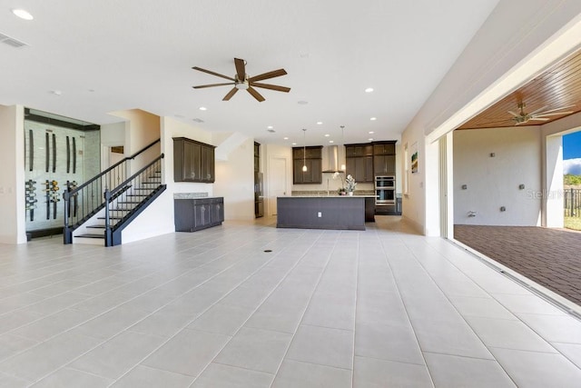 unfurnished living room featuring a ceiling fan, recessed lighting, stairway, and light tile patterned floors