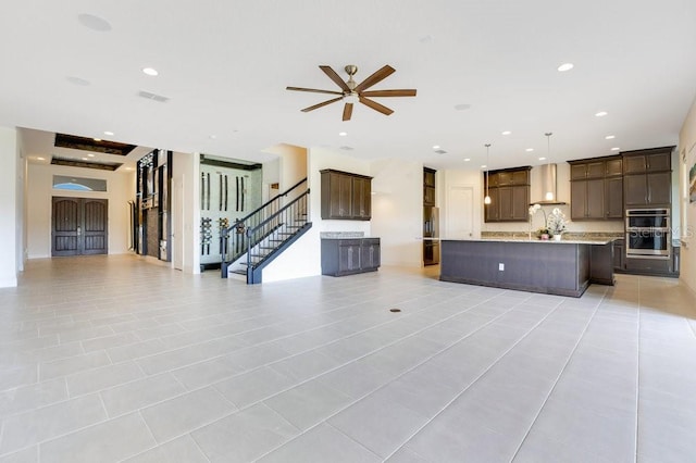 unfurnished living room with light tile patterned floors, visible vents, a ceiling fan, stairs, and recessed lighting