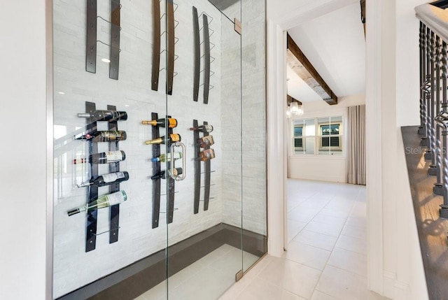 wine room featuring vaulted ceiling with beams and light tile patterned floors