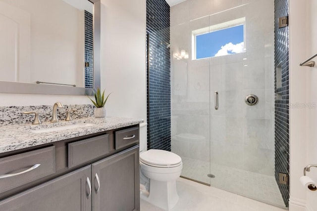 bathroom featuring toilet, vanity, and a shower stall