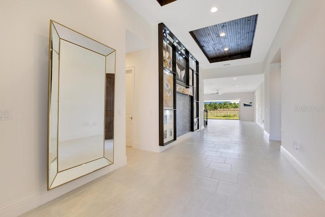 hallway featuring baseboards, light tile patterned floors, and recessed lighting