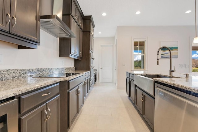 kitchen with pendant lighting, light stone countertops, dishwasher, wall chimney exhaust hood, and black electric cooktop