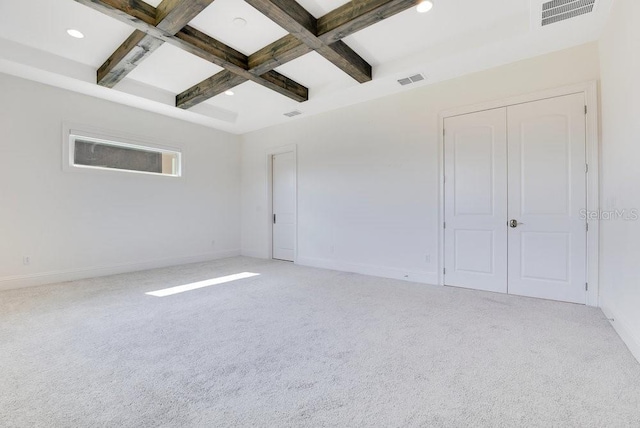 empty room featuring visible vents, coffered ceiling, beamed ceiling, and light colored carpet