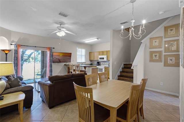 tiled dining space with ceiling fan with notable chandelier, a textured ceiling, and vaulted ceiling