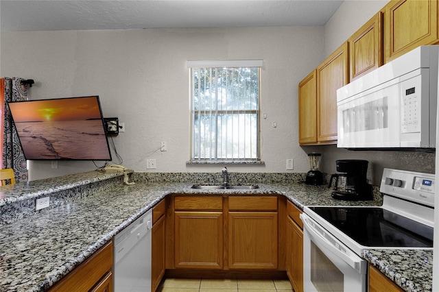 kitchen featuring sink, light tile patterned flooring, stone countertops, and white appliances