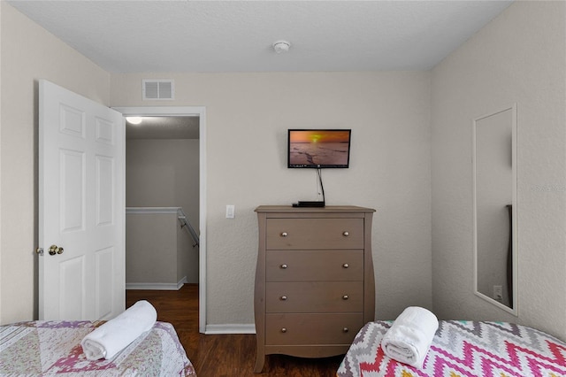 bedroom with dark hardwood / wood-style flooring