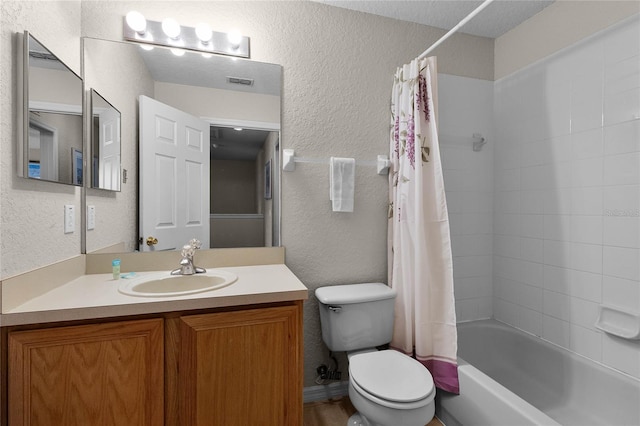 full bathroom featuring shower / tub combo, vanity, a textured ceiling, and toilet