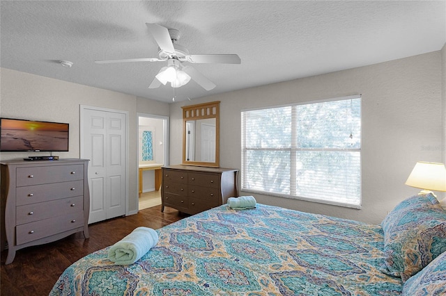 bedroom with a closet, a textured ceiling, dark hardwood / wood-style floors, and ceiling fan