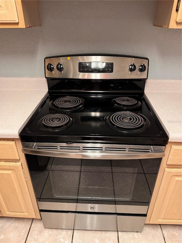 room details featuring electric stove and light brown cabinets