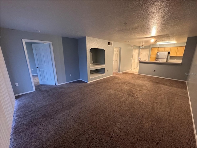 unfurnished living room with a textured ceiling and carpet flooring