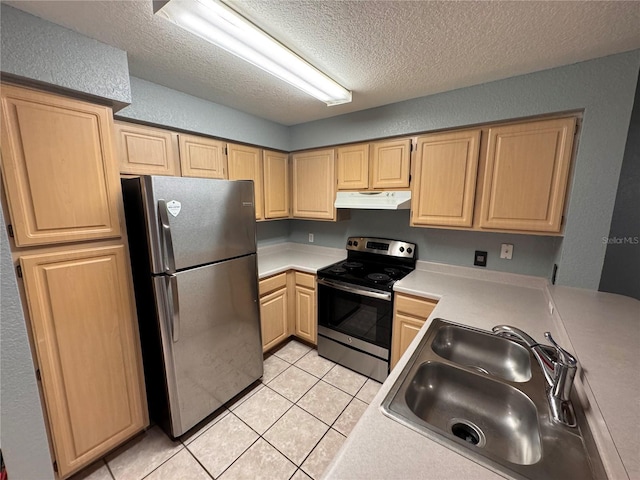 kitchen featuring appliances with stainless steel finishes, sink, a textured ceiling, and light tile patterned floors