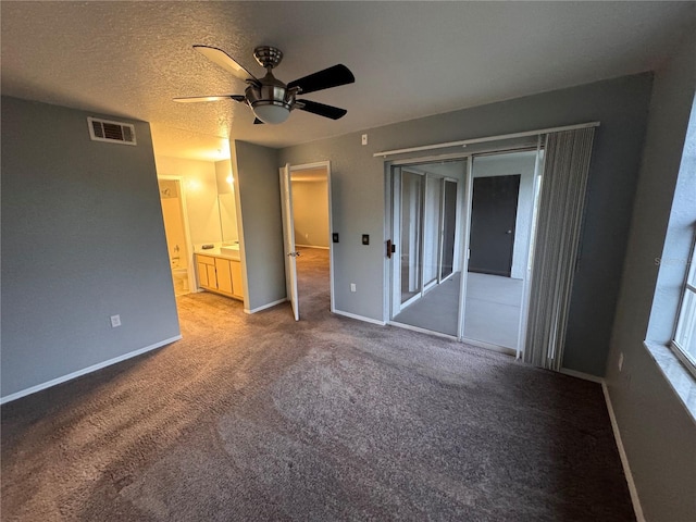 unfurnished bedroom with ensuite bath, ceiling fan, carpet, a textured ceiling, and access to outside