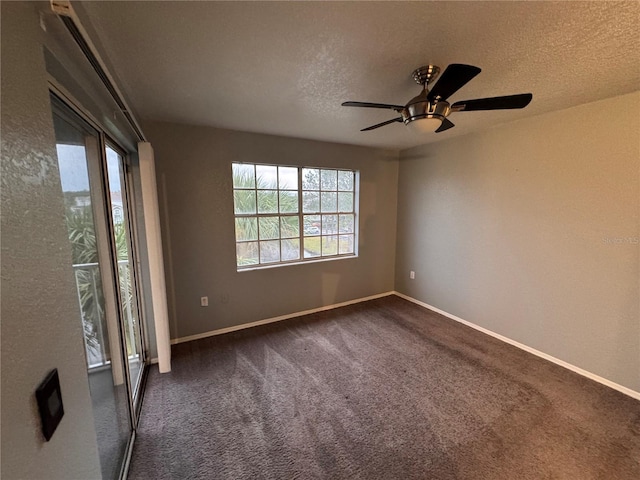 empty room featuring dark colored carpet, ceiling fan, and a textured ceiling