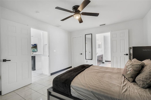 bedroom with ensuite bathroom, ceiling fan, and light tile patterned floors