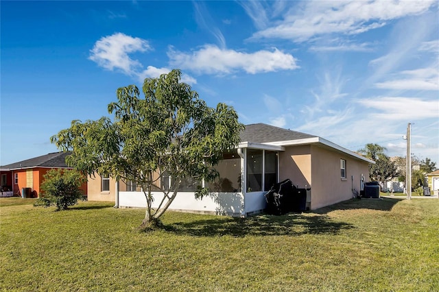 view of property exterior with a yard, central AC unit, and a sunroom