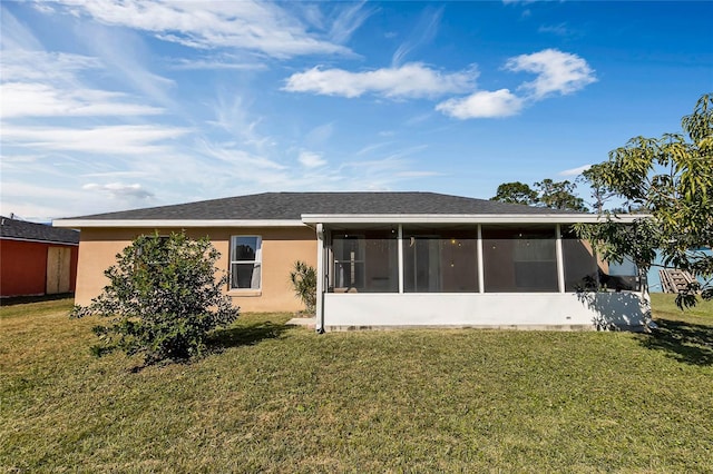 rear view of property with a yard and a sunroom