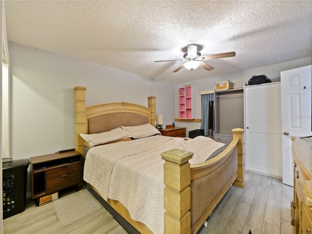 bedroom featuring a textured ceiling, light hardwood / wood-style floors, and ceiling fan