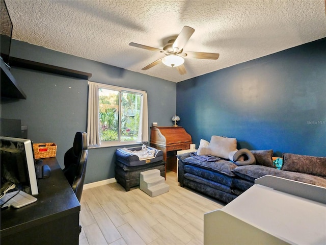 interior space with ceiling fan, a textured ceiling, and light hardwood / wood-style flooring