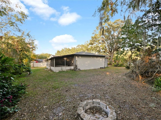 view of yard with a sunroom and a fire pit