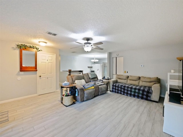 living room with a textured ceiling and light wood-type flooring