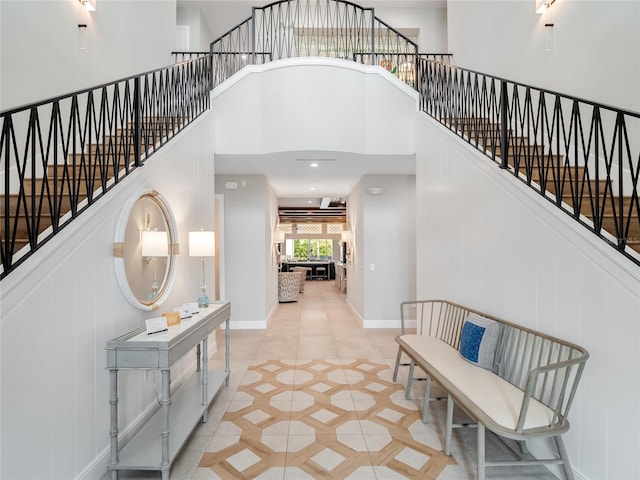 entryway featuring a towering ceiling and light tile patterned floors