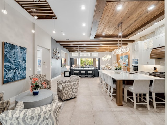 interior space with beamed ceiling, wood ceiling, sink, and a chandelier