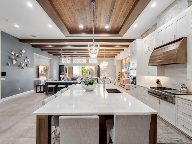 kitchen featuring a breakfast bar, stainless steel gas cooktop, sink, pendant lighting, and a large island