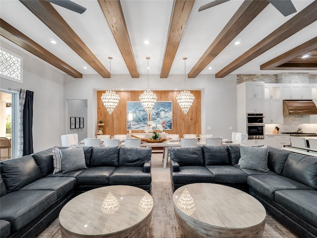 living room featuring beamed ceiling and an inviting chandelier