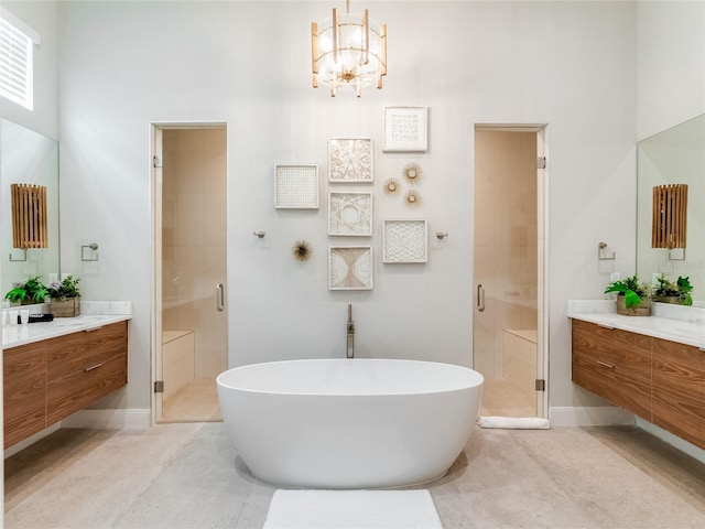 bathroom featuring tile patterned floors, vanity, plus walk in shower, and an inviting chandelier