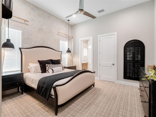 bedroom with connected bathroom, ceiling fan, and light carpet