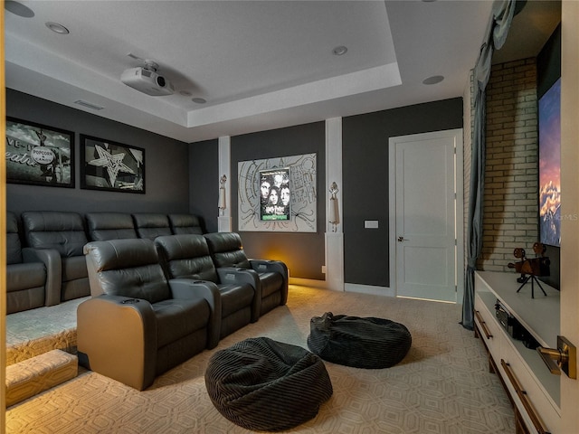 carpeted cinema room with a tray ceiling