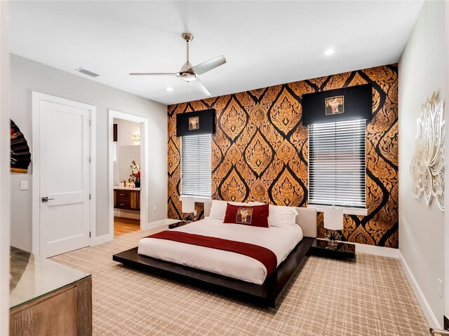 carpeted bedroom featuring ensuite bath and ceiling fan