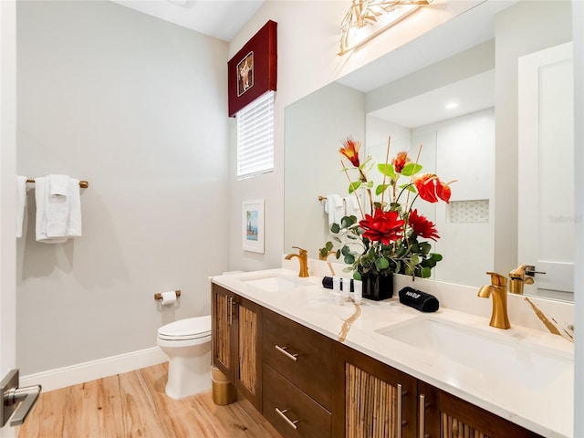 bathroom with hardwood / wood-style floors, vanity, and toilet