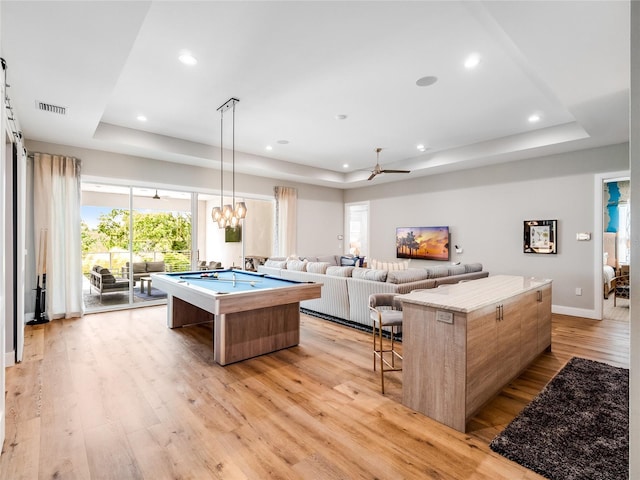 recreation room featuring a raised ceiling, light hardwood / wood-style flooring, ceiling fan, and pool table