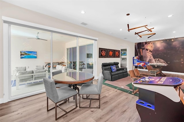 dining room featuring light hardwood / wood-style flooring and ceiling fan with notable chandelier