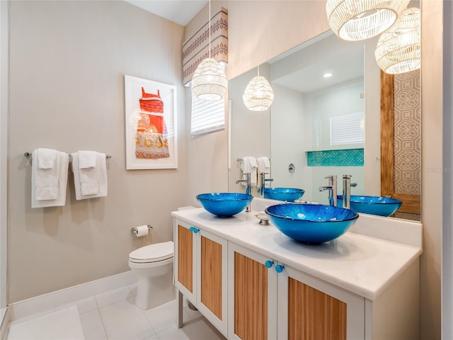 bathroom featuring tile patterned floors, toilet, vanity, and an inviting chandelier