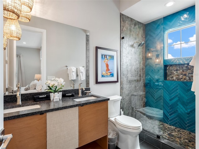 bathroom featuring a tile shower, vanity, toilet, and tile patterned floors