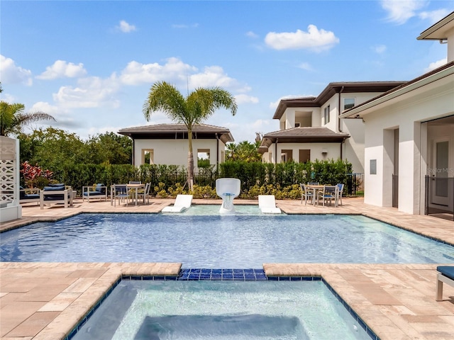 view of pool featuring an in ground hot tub and a patio