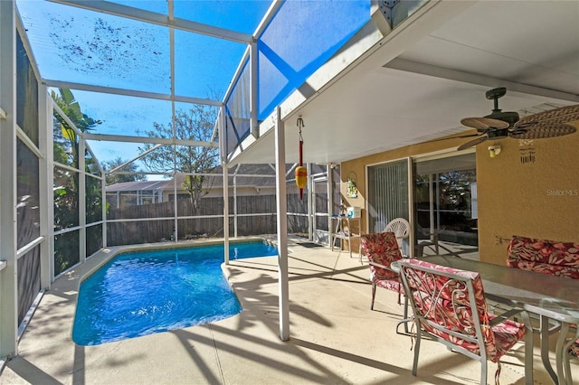 view of pool with a patio, glass enclosure, and ceiling fan