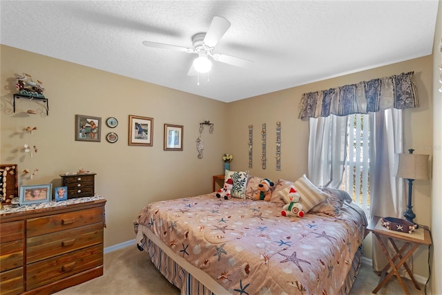 bedroom featuring light carpet, a textured ceiling, and ceiling fan