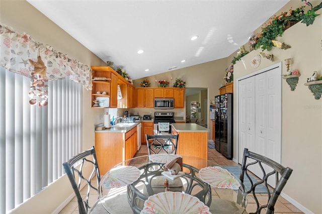 kitchen featuring electric range, a kitchen island, black fridge, vaulted ceiling, and light tile patterned flooring