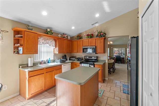 kitchen featuring sink, a textured ceiling, vaulted ceiling, a kitchen island, and appliances with stainless steel finishes